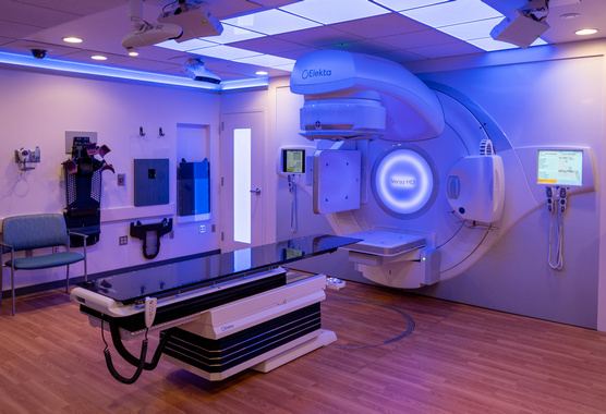 Modern radiation therapy suite featuring a linear accelerator and treatment couch.