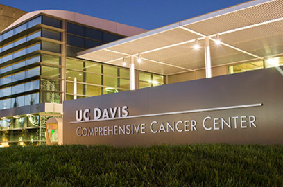Exterior view of the UC Davis Comprehensive Cancer Center building at dusk.