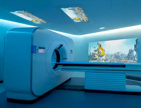 CT simulation room with a large scanner, patient table, blue ambient lighting, and an underwater-themed wall mural.