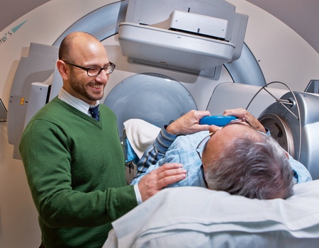 Radiologist attending to a patient positioned inside a large radiation therapy machine.