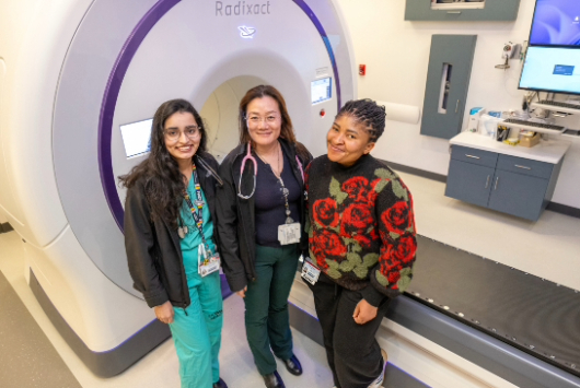 Radiation oncology residents in front of a treatment machine