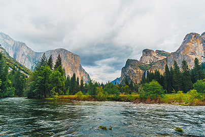 River with trees and large cliffs in the background
