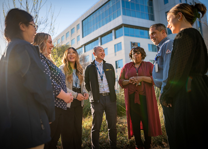 Seven UC Davis health staff members gathered outside in a courtyard.